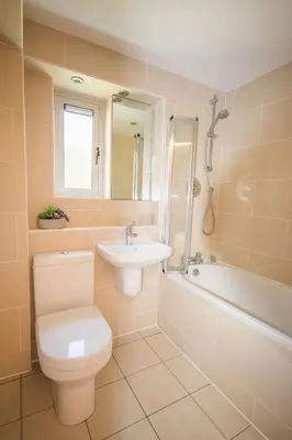 a bathroom with a toilet and a sink and a tub at Porth Sands Beachfront Apartment in Newquay