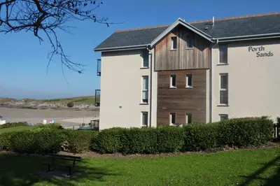 a building with a sign on the side of it at Porth Sands Beachfront Apartment in Newquay