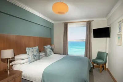a bedroom with a bed and a window with the ocean at Esplanade Hotel in Newquay