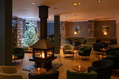 a hotel lobby with a fireplace and a christmas tree at Esplanade Hotel in Newquay