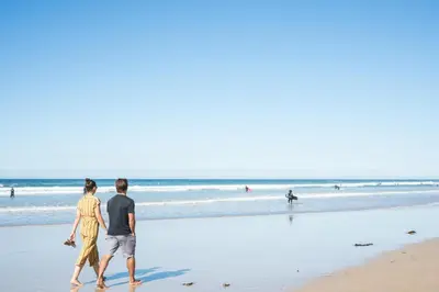 a man and a woman walking on the beach at Esplanade Hotel in Newquay