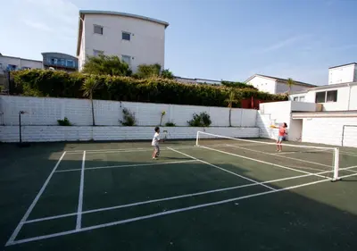 two children playing tennis on a tennis court at Esplanade Hotel in Newquay