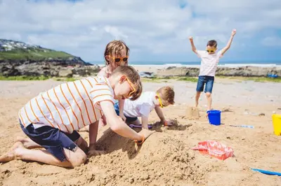 three children playing in the sand on the beach at Esplanade Hotel in Newquay