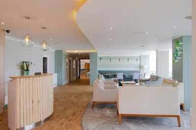 a living room with white furniture and a table at Esplanade Hotel in Newquay