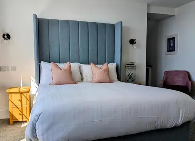a bedroom with a large bed with pink pillows at The Westcott by the Sea - Just for Adults in Falmouth