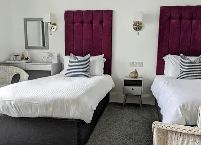 two beds in a room with purple headboards at The Westcott by the Sea - Just for Adults in Falmouth