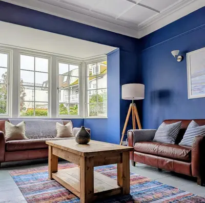 a living room with blue walls and a coffee table at The Westcott by the Sea - Just for Adults in Falmouth