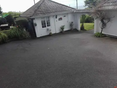 a driveway in front of a white house at Camellia Chalet in Germoe