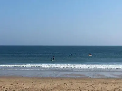 a group of people on surfboards in the ocean at Camellia Chalet in Germoe