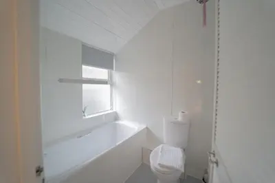a white bathroom with a tub and a toilet at Sea Bed Guesthouse in Newquay