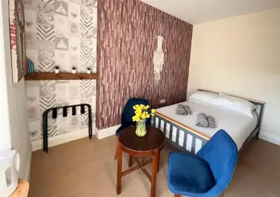 a small bedroom with a bed and a table and a chair at Sea Bed Guesthouse in Newquay