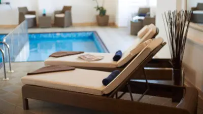 two beds sitting next to a swimming pool at The Royal Duchy Hotel in Falmouth