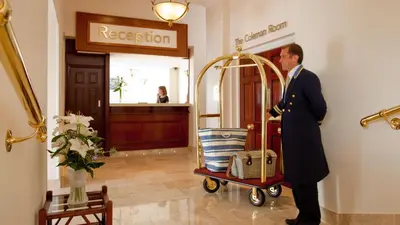 a man in a suit pushing a luggage cart at The Royal Duchy Hotel in Falmouth