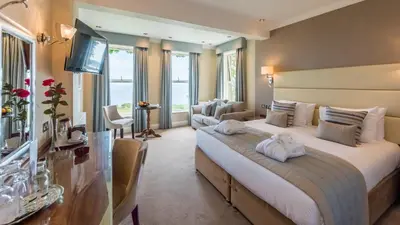a hotel room with a large bed and a television at The Carlyon Bay Hotel and Spa in St Austell