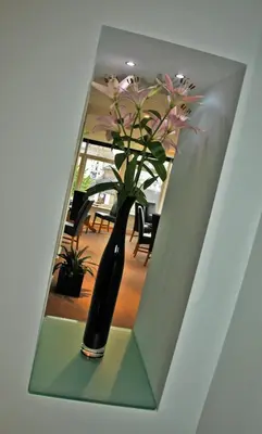 a vase with flowers sitting on a shelf at Westberry Hotel in Bodmin