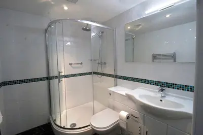 a bathroom with a shower and a toilet and a sink at Westberry Hotel in Bodmin