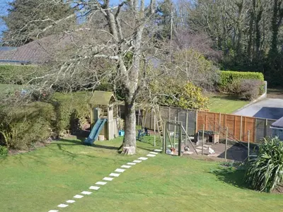 a yard with a tree and a playground at Trelawne Hotel in Falmouth