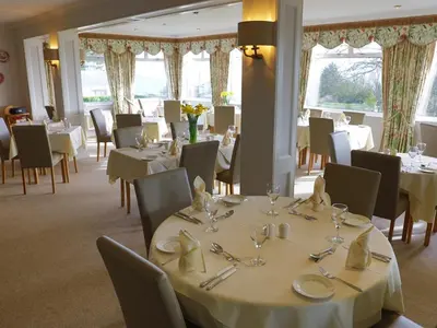 a dining room with white tables and chairs at Trelawne Hotel in Falmouth