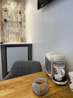 a coffee maker sitting on a wooden table next to a coffee pot at Wenden Guest House in Newquay