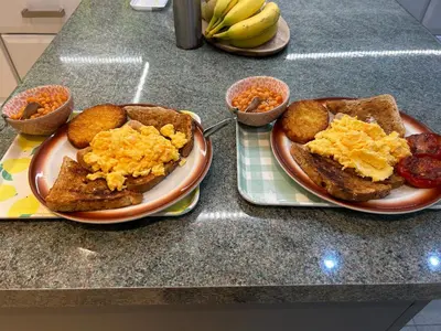 two plates of breakfast food on a counter with toast at Wenden Guest House in Newquay