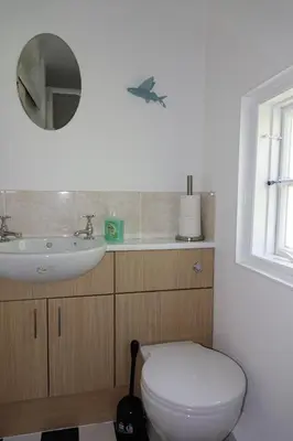 a bathroom with a white toilet and a sink at Saffron House in Fowey
