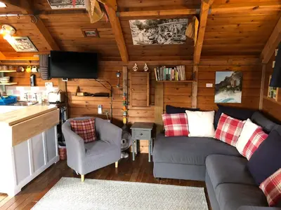 a living room with a couch and chairs in a cabin at Enys Boathouse in Porkellis