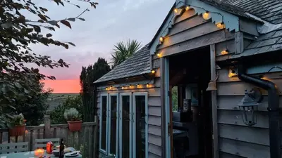 a house with lights on the side of it at Enys Boathouse in Porkellis
