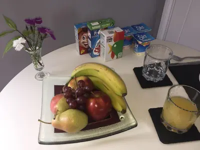 a plate of fruit on a table with a glass of orange juice at Rosenn Teyr in St. Agnes