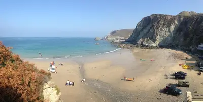 a group of people on a beach near the ocean at Rosenn Teyr in St. Agnes