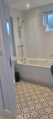 a bathroom with a shower and a tub and a sink at Peacock Lodge - Sleeps 4 - 2 Bedrooms in East Looe
