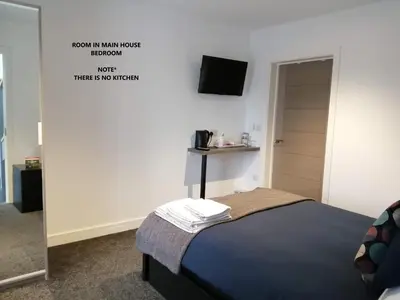 a small bedroom with a bed and a mirror at Boleyn house in Bodmin
