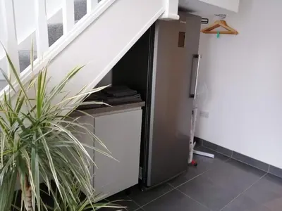 a room with a refrigerator under a staircase at Boleyn house in Bodmin