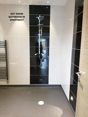 a bathroom with a black and white tiled wall at Boleyn house in Bodmin