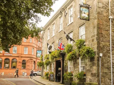 a building with a clock on it on a street at The White Hart Hotel in St Austell