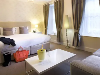a hotel room with a bed and a table and a couch at The White Hart Hotel in St Austell