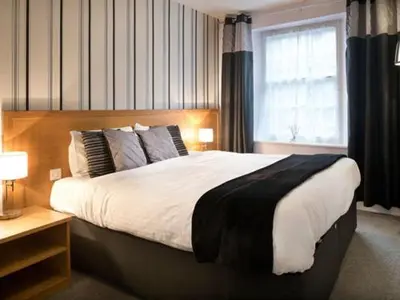 a bedroom with a large bed and a window at The White Hart Hotel in St Austell