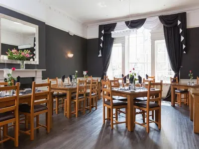 a dining room with wooden tables and chairs at The White Hart Hotel in St Austell