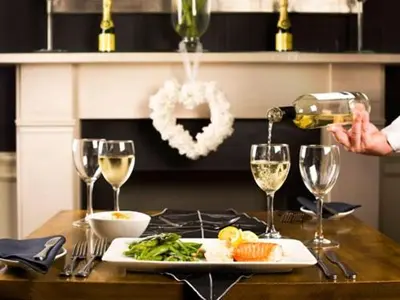 a person pouring wine into a plate of food on a table at The White Hart Hotel in St Austell