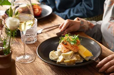 a table with a plate of food and a glass of wine at Rashleigh Arms in St Austell
