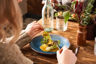 a woman sitting at a table eating a plate of food at Rashleigh Arms in St Austell