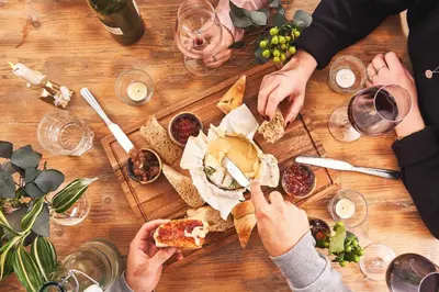 a group of people sitting around a wooden table eating pizza at Rashleigh Arms in St Austell