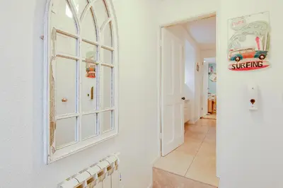a hallway with a window and a white door at Rosevean Cottage St Agnes in St. Agnes