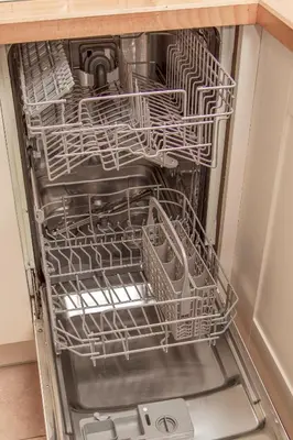 an empty dishwasher with dishes inside of it at Rosevean Cottage St Agnes in St. Agnes