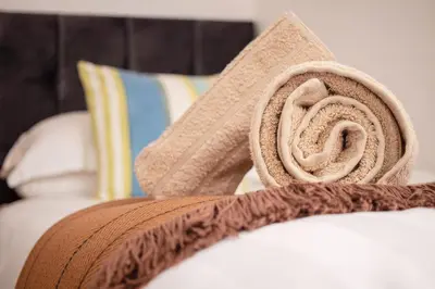a pile of towels sitting on top of a bed at Rosevean Cottage St Agnes in St. Agnes