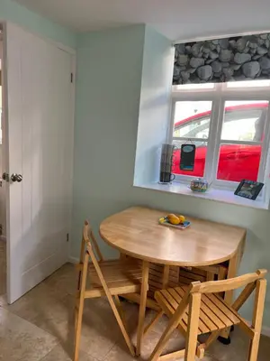 a table and chairs in a kitchen with a window at Rosevean Cottage St Agnes in St. Agnes