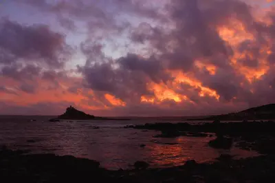 a sunset over the ocean with a cloudy sky at Wheal Rodney Holiday Park in Marazion
