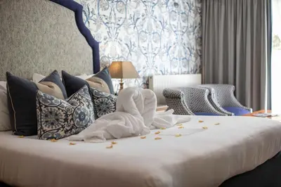 a bedroom with a large white bed with pillows at Penventon Park Hotel in Redruth