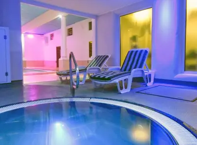 a swimming pool with two chairs and a swimming pool at Penventon Park Hotel in Redruth