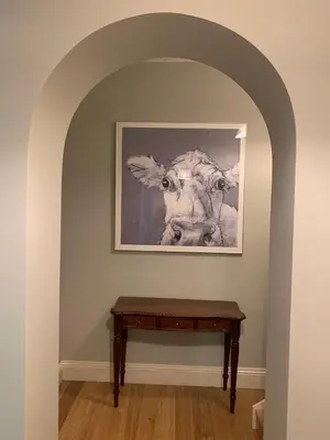 a picture of a cow on the wall next to a table at Boscundle Manor in St Austell