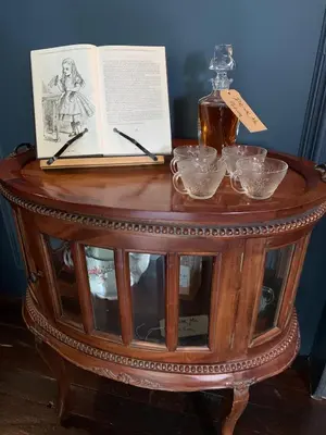 a table with a book and a bottle and glasses at Boscundle Manor in St Austell